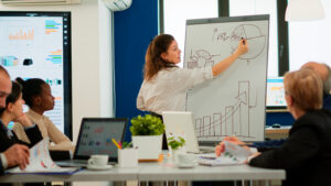 Focused Team Leader Presenting Marketing Plan Interested Multiracial Coworkers Serious Speaker Boss Executive Business Trainer Explaining Development Strategy Motivated Mixed Race Employees