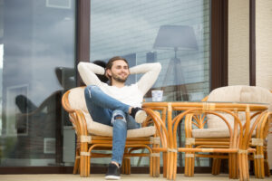 Smiling Relaxed Man Enjoying Pleasant Morning Sitting On Terrace
